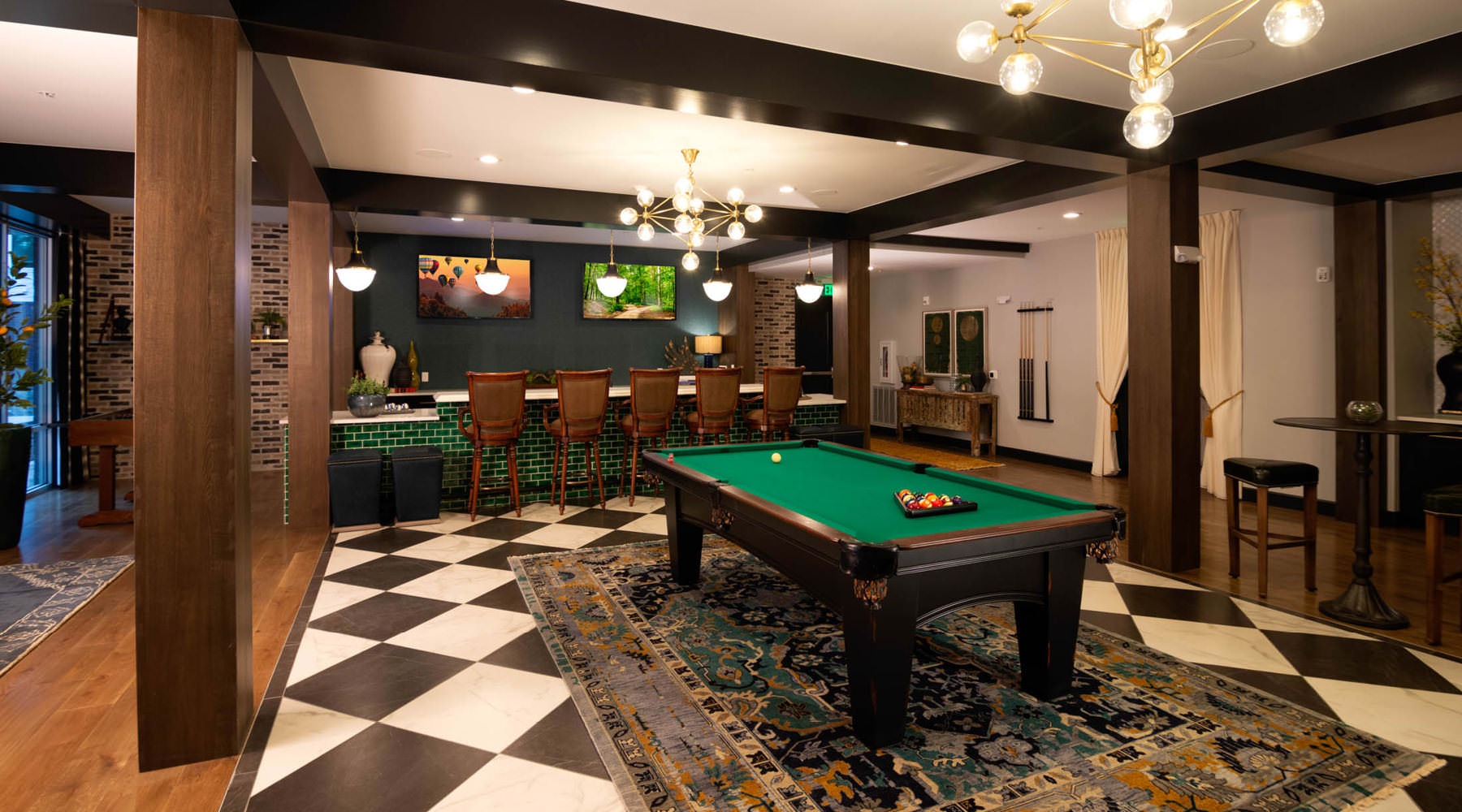 billiards table in clubhouse brightened by beautiful chandeliers