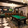 billiards table in clubhouse brightened by beautiful chandeliers